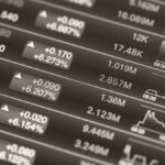 Stock market dashboard with numbers, arrows, and small line charts representing trading data.