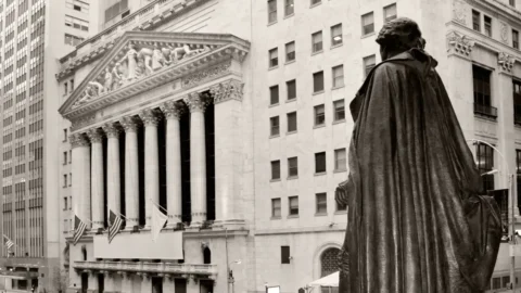 Market Update - July 2026 | Rhame & Gorrell Wealth Management Bronze statue in the foreground with a cloaked back, facing a grand neoclassical courthouse with tall columns and flags in the background.